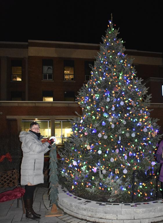 Sandra Beimers pushes button to light tree